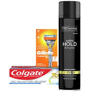 A gillette fusion5 razor with packaging, a tube of colgate toothpaste, and a can of tresemmé extra hold hairspray arranged against a white background.